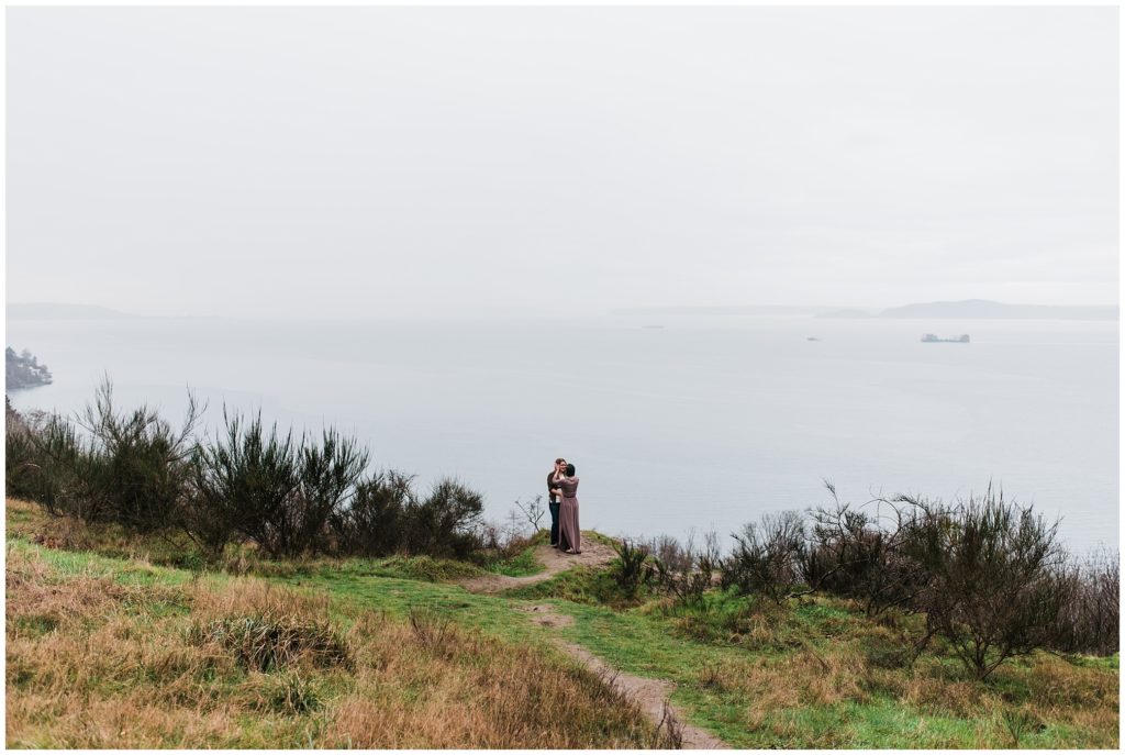 LGBTQ couple embracing in Discovery Park for their Seattle engagement photos