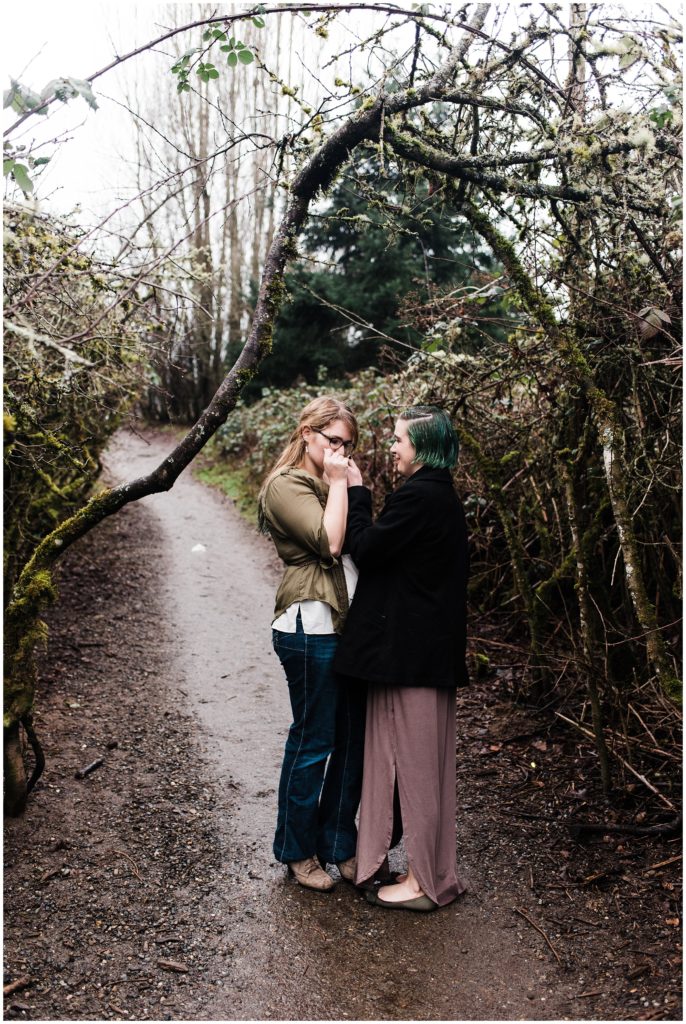 Discovery Park engagement session, LGBTQ couple kissing each other's hands