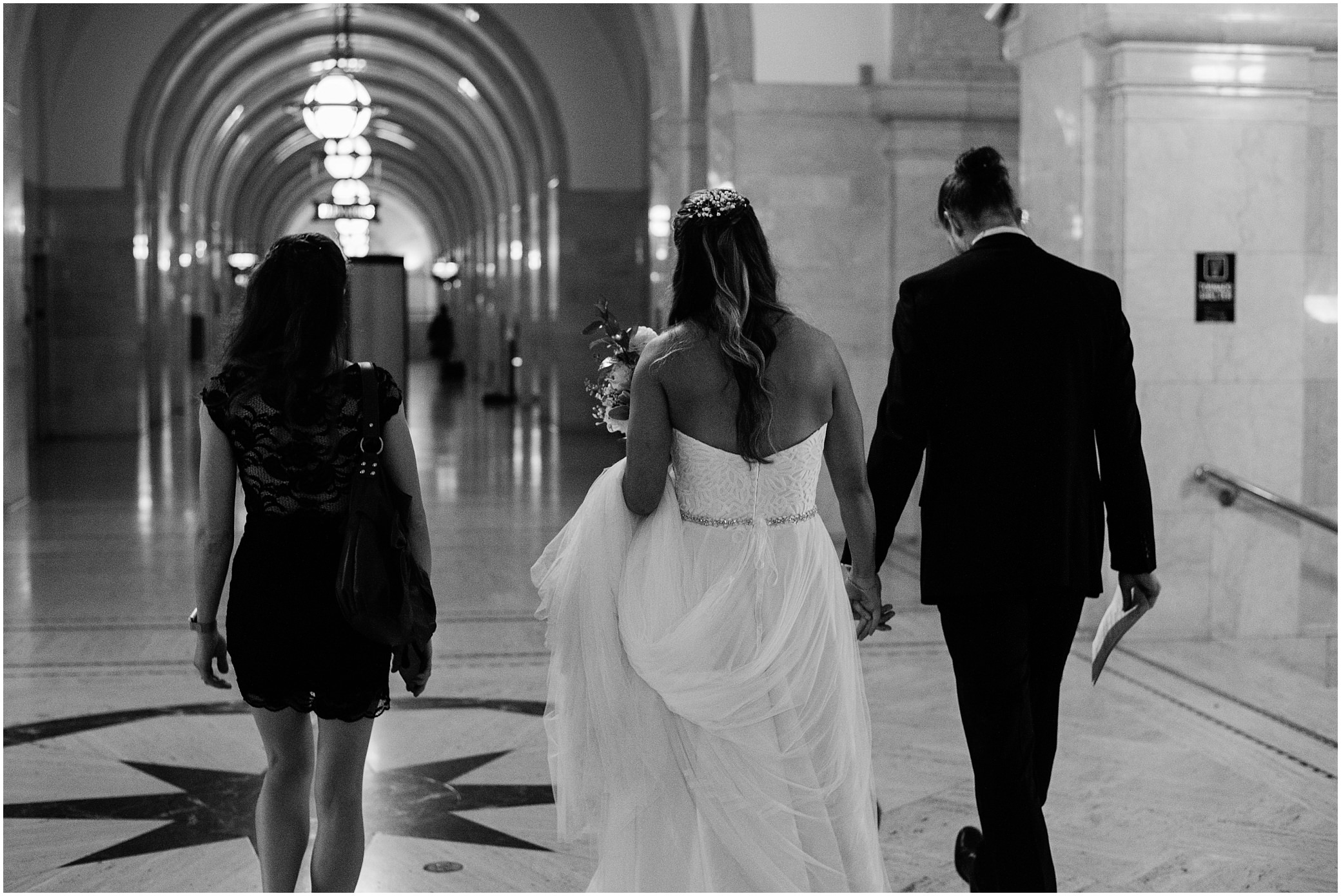 Courthouse weddings are the best! A newly married couple walks down the hall in the Milwaukee courthouse, holding hands.