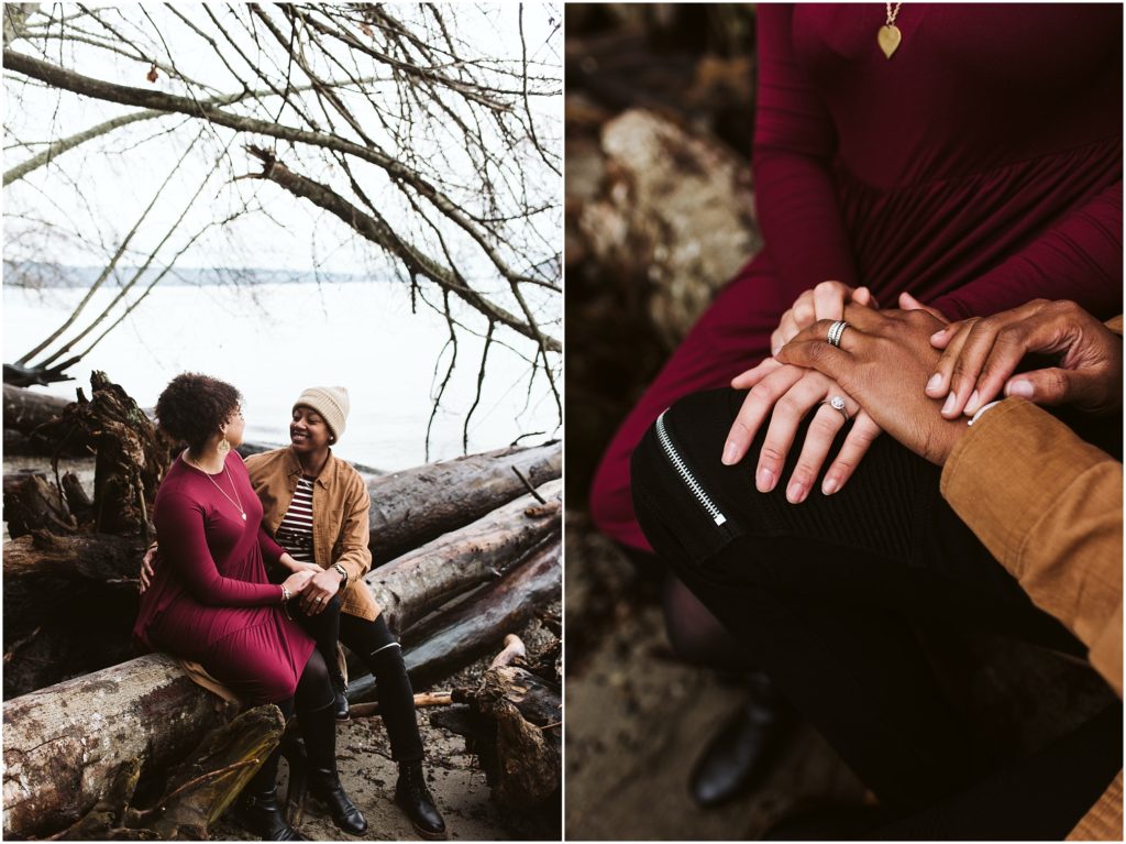 An LGBTQ+ couple shows their engagement rings on the shore of Puget Sound during their Point Defiance engagement session