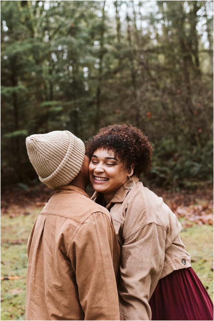 An LGBTQ+ couple kissing and giggling during their Point Defiance engagement session