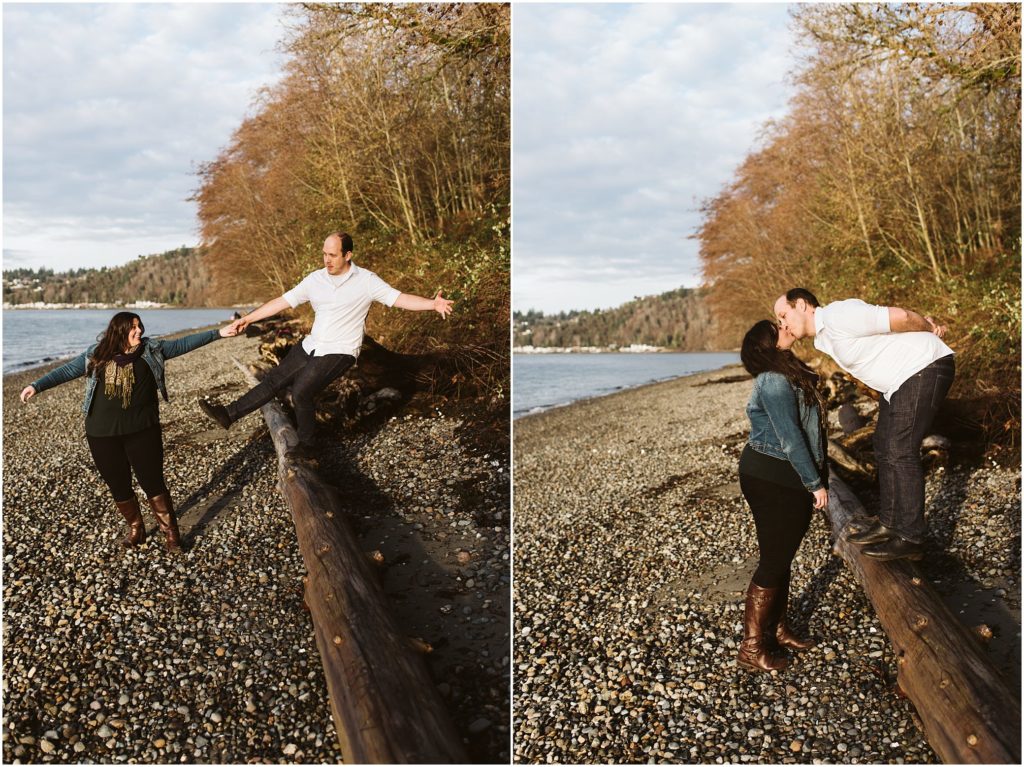 An engaged couple playing on a log on the beach during their Seahurst Park engagement session