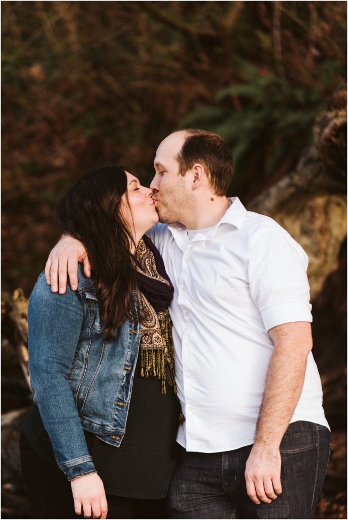 An engaged couple kissing during their Seahurst Park engagement session