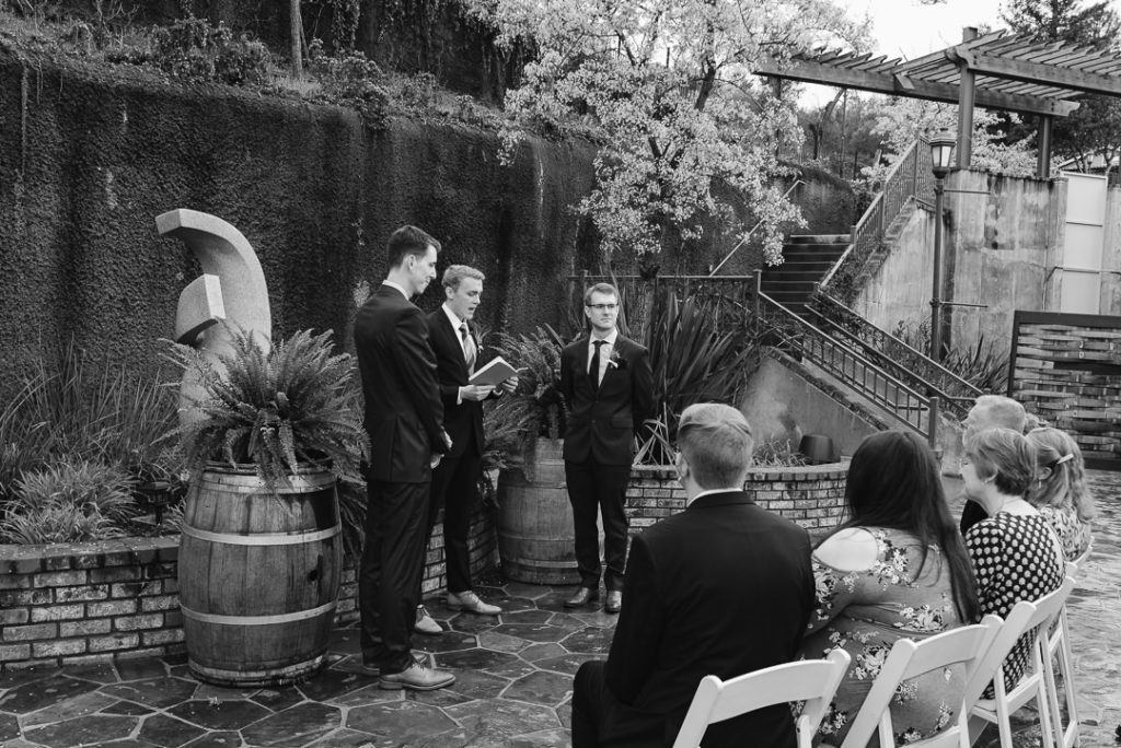 An officiant leads an intimate ceremony for two marriers at a winery.
